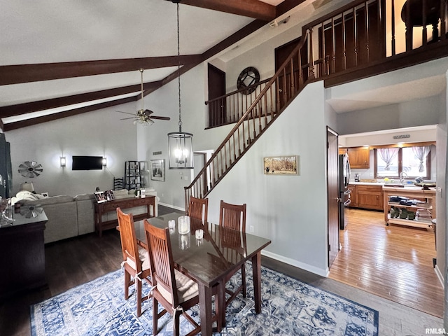 dining room with stairway, light wood-style flooring, baseboards, and beamed ceiling