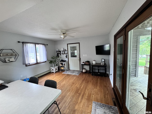 office area featuring a textured ceiling, wood finished floors, ceiling fan, and a baseboard radiator