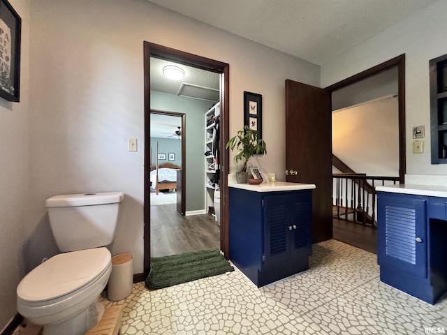 ensuite bathroom featuring vanity, ensuite bath, toilet, and wood finished floors