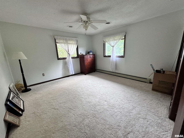 unfurnished bedroom with a baseboard heating unit, multiple windows, a textured ceiling, and light colored carpet