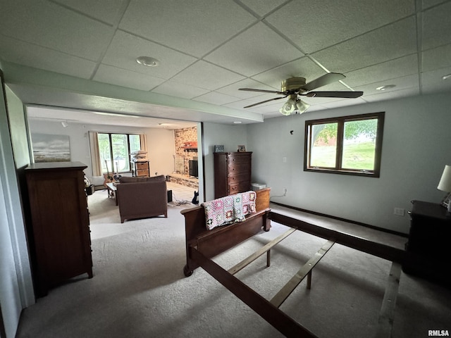 bedroom featuring a drop ceiling, baseboards, and a ceiling fan