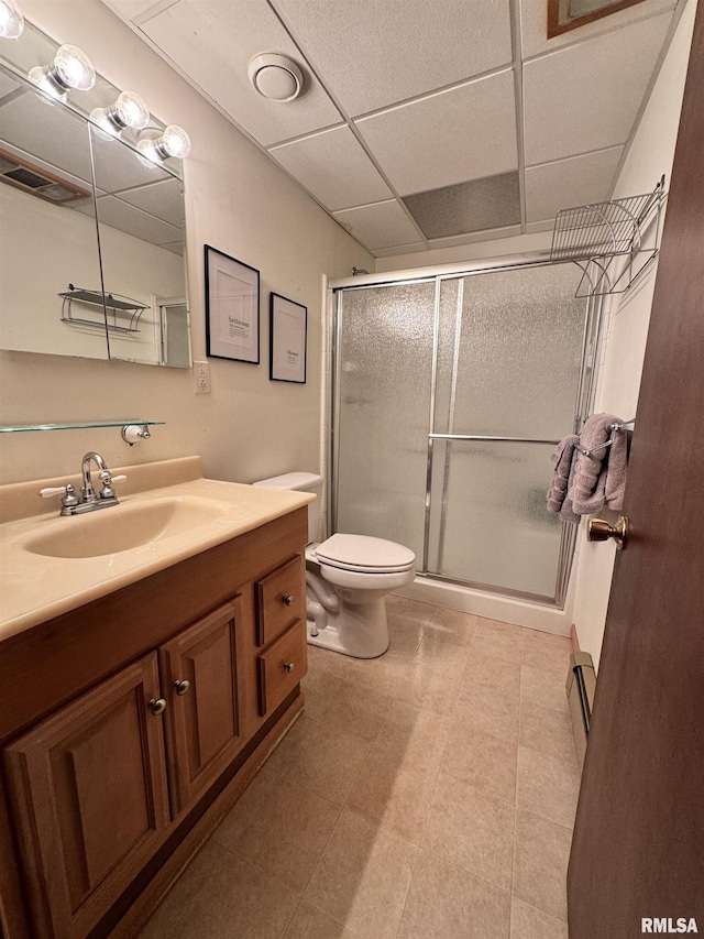 full bath featuring vanity, a stall shower, a paneled ceiling, a baseboard heating unit, and toilet