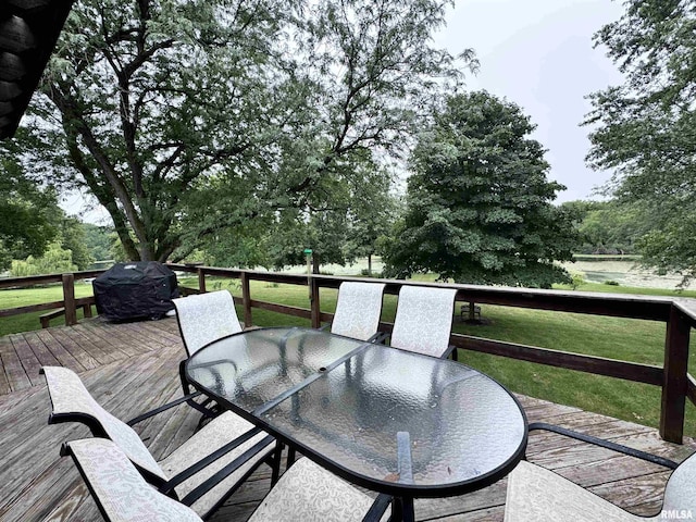 wooden deck featuring a grill, outdoor dining area, and a yard