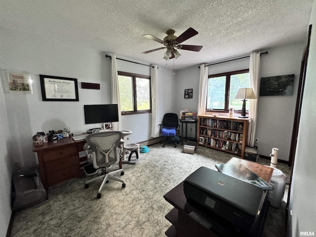 carpeted office space featuring a wealth of natural light, a textured ceiling, and ceiling fan