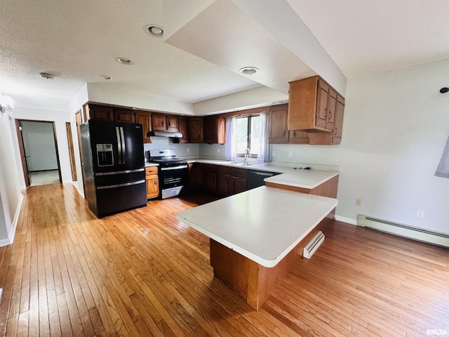 kitchen featuring a sink, light wood-style floors, black appliances, and light countertops