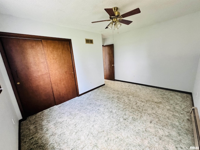 unfurnished bedroom featuring visible vents, a textured ceiling, a closet, carpet, and baseboards