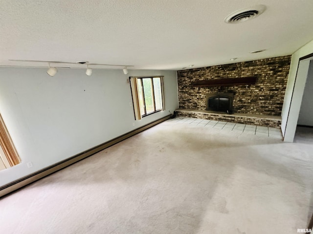 unfurnished living room with visible vents, track lighting, a baseboard heating unit, carpet flooring, and a textured ceiling