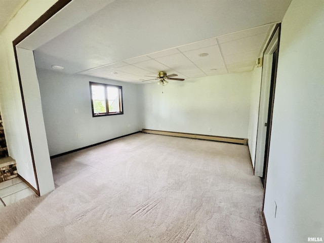 unfurnished room featuring carpet floors, a paneled ceiling, a ceiling fan, and a baseboard radiator