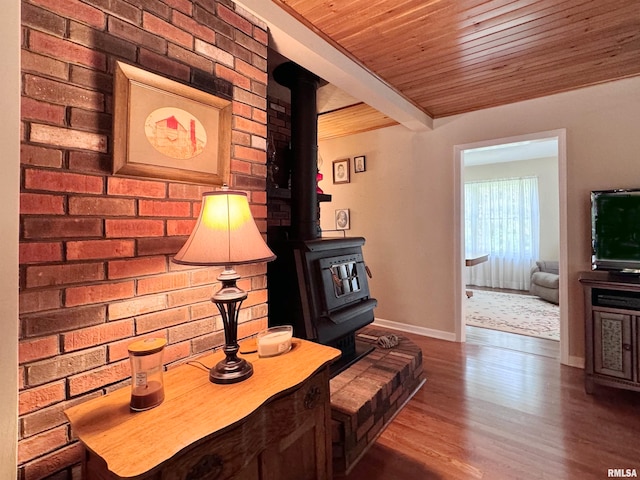 living area featuring a wood stove, beamed ceiling, wood ceiling, and dark hardwood / wood-style flooring