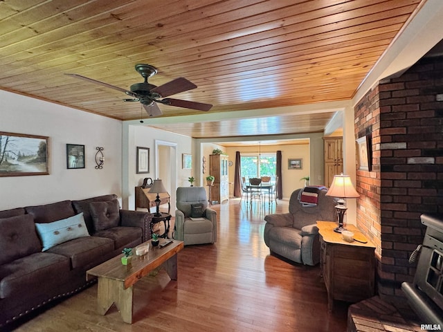 living room with wood ceiling, wood-type flooring, ornamental molding, and ceiling fan