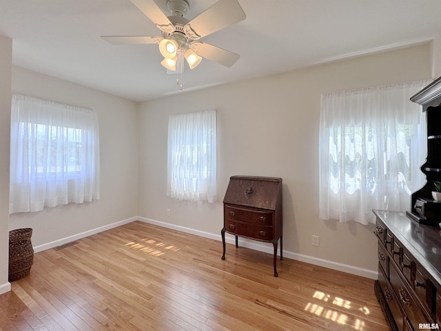 living area with ceiling fan and light hardwood / wood-style flooring