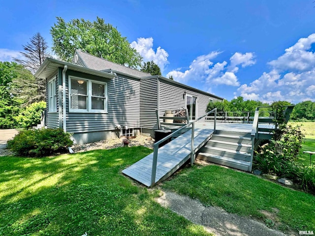 back of house with a wooden deck and a yard