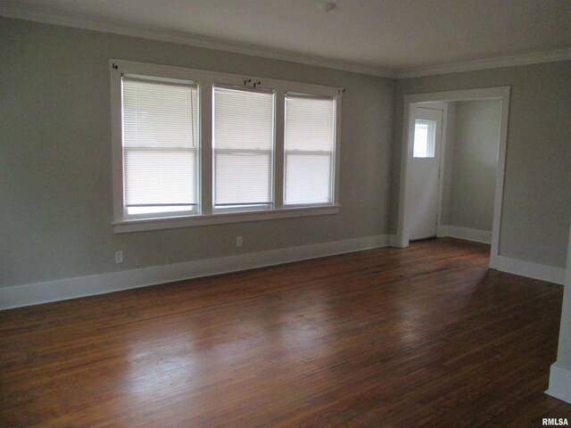 spare room featuring crown molding and dark wood-type flooring