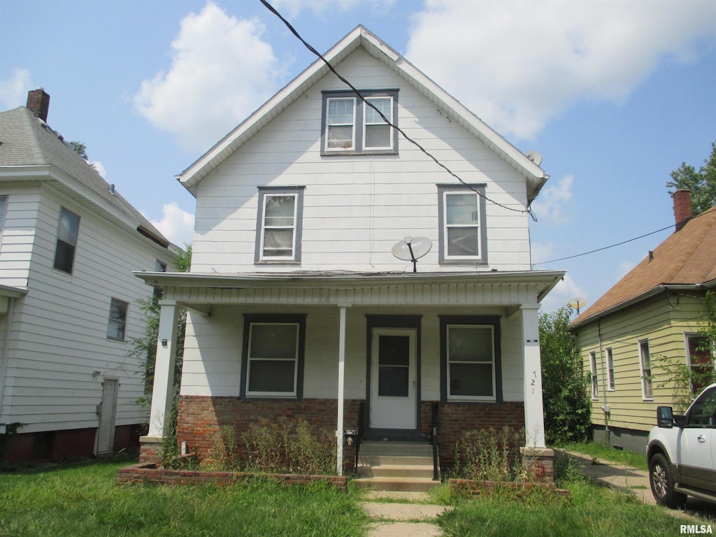 american foursquare style home featuring covered porch and brick siding