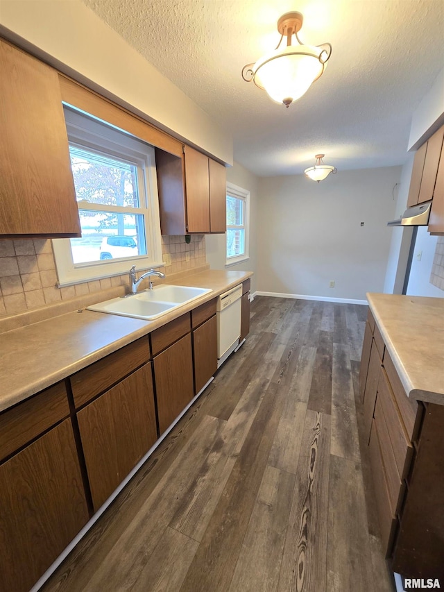 kitchen featuring sink, light hardwood / wood-style flooring, dishwasher, backsplash, and a textured ceiling