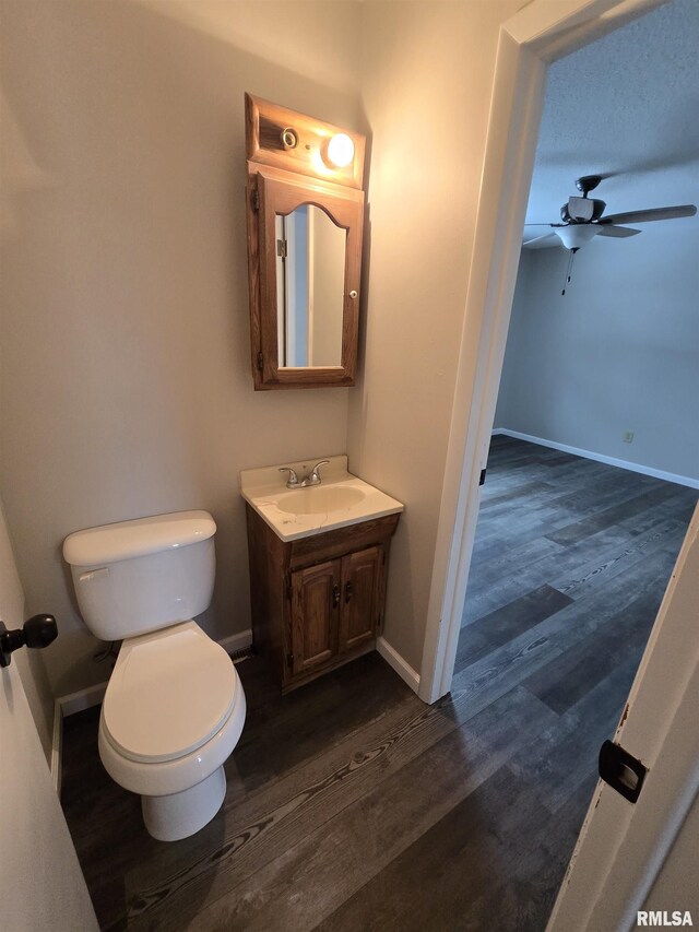 1638 Knox Highway 15, Dahinda, IL 61428 - half bathroom with vanity, toilet, wood finished floors, ceiling fan, and baseboards