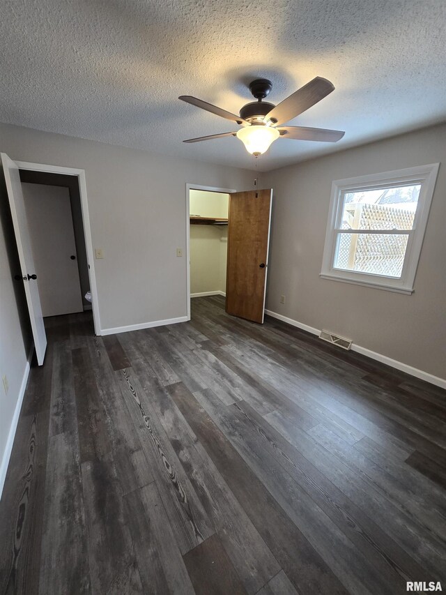 1638 Knox Highway 15, Dahinda, IL 61428 - unfurnished bedroom featuring a textured ceiling, dark wood finished floors, baseboards, a ceiling fan, and a closet