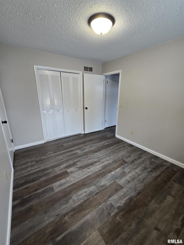 1638 Knox Highway 15, Dahinda, IL 61428 - unfurnished bedroom with a closet, dark wood-style flooring, a textured ceiling, and baseboards