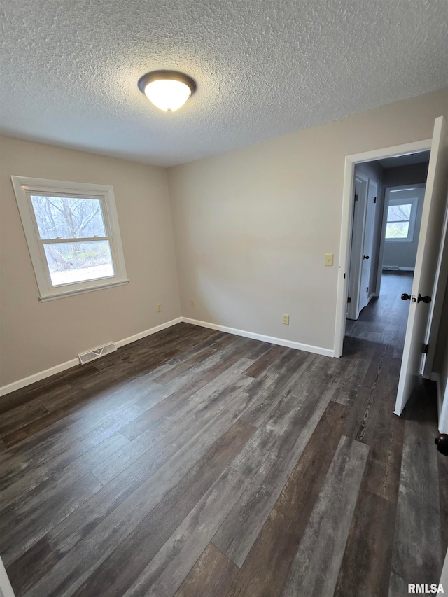 carpeted empty room featuring a textured ceiling