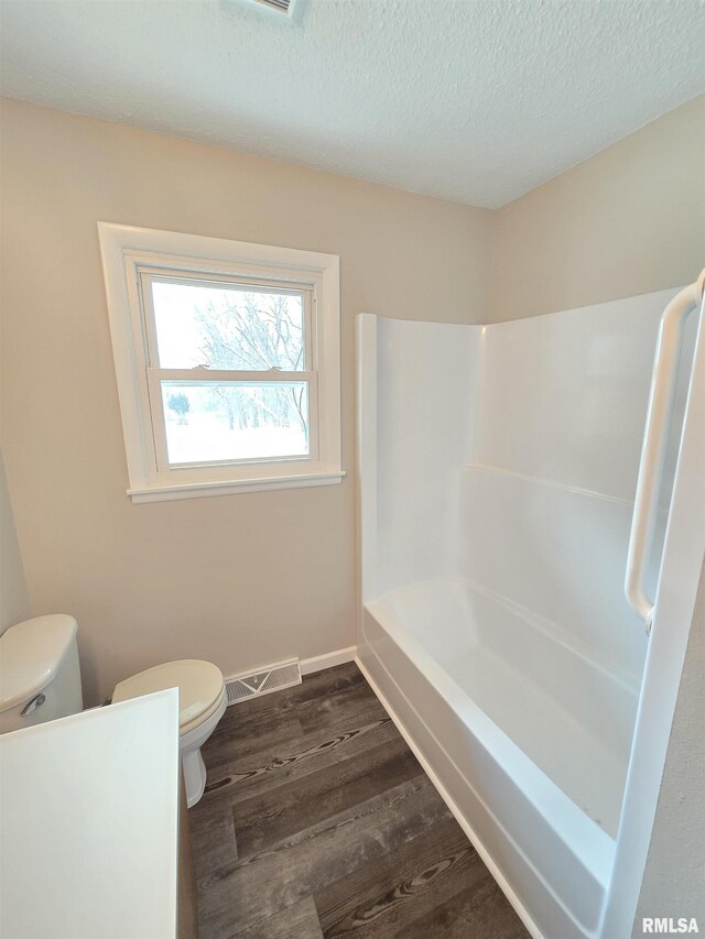 1638 Knox Highway 15, Dahinda, IL 61428 - bathroom with toilet, wood finished floors, a textured ceiling,  shower combination, and baseboards