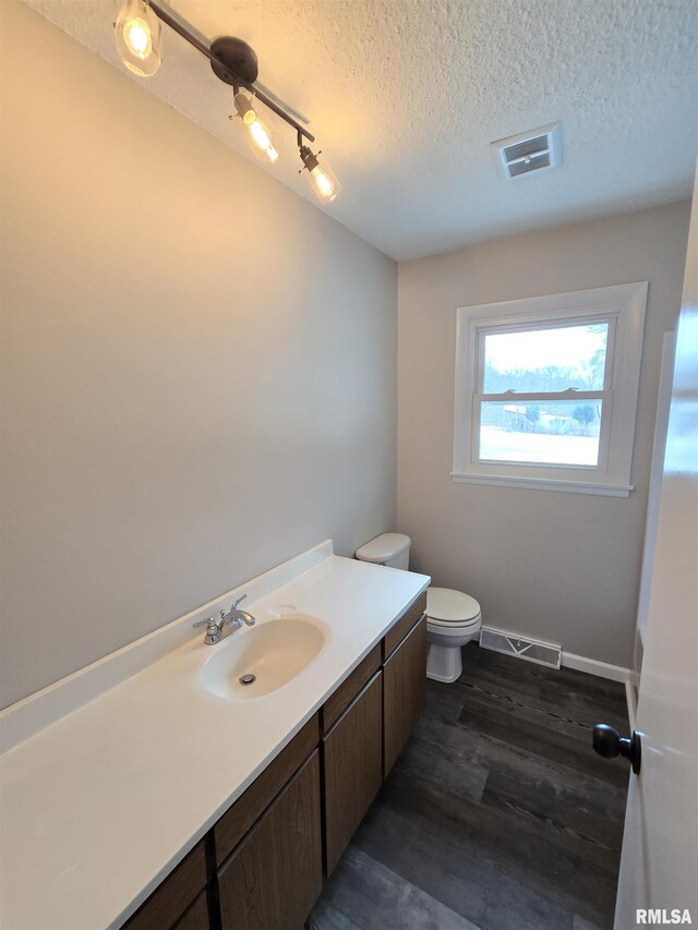 1638 Knox Highway 15, Dahinda, IL 61428 - bathroom with toilet, a textured ceiling, vanity, wood finished floors, and track lighting
