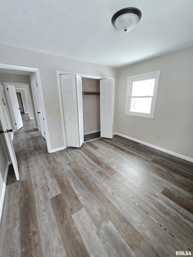 1638 Knox Highway 15, Dahinda, IL 61428 - unfurnished bedroom featuring a closet, baseboards, dark wood-type flooring, and a textured ceiling
