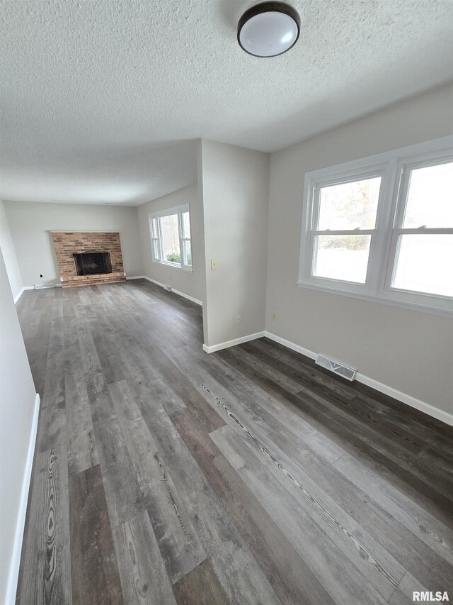 1638 Knox Highway 15, Dahinda, IL 61428 - unfurnished living room with a textured ceiling, dark wood-style flooring, baseboards, and a fireplace