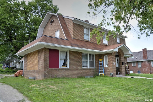 view of front facade with a front yard and central air condition unit