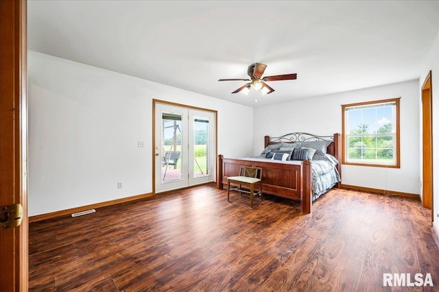 bedroom featuring multiple windows, wood-type flooring, and access to exterior