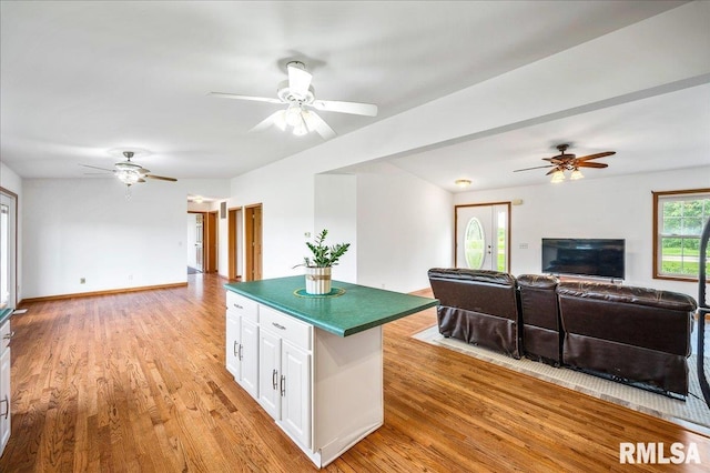 kitchen with ceiling fan, light hardwood / wood-style floors, and white cabinets