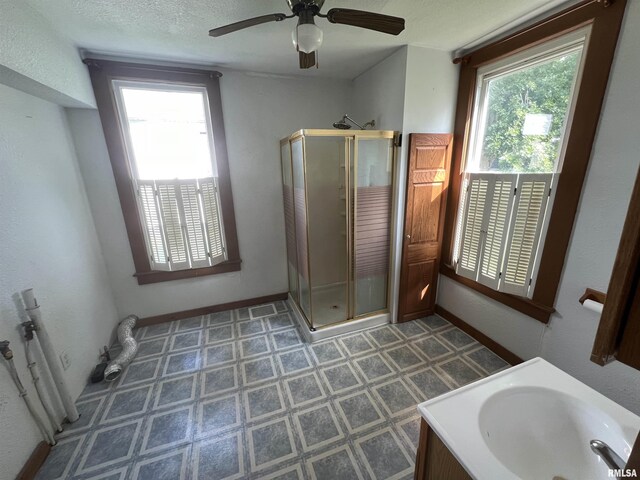 bathroom featuring ceiling fan, an enclosed shower, vanity, tile patterned floors, and a textured ceiling