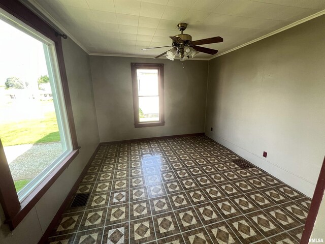 tiled empty room with ceiling fan and ornamental molding