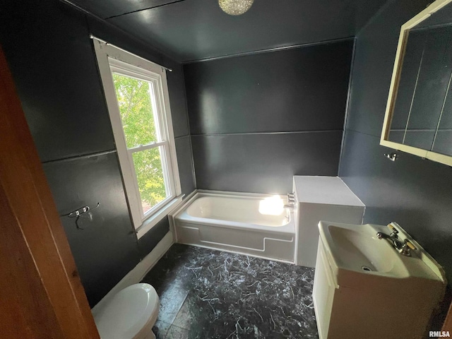 bathroom featuring tile patterned flooring, a washtub, vanity, and toilet