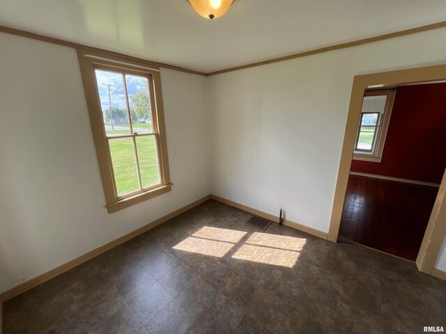 tiled spare room featuring crown molding