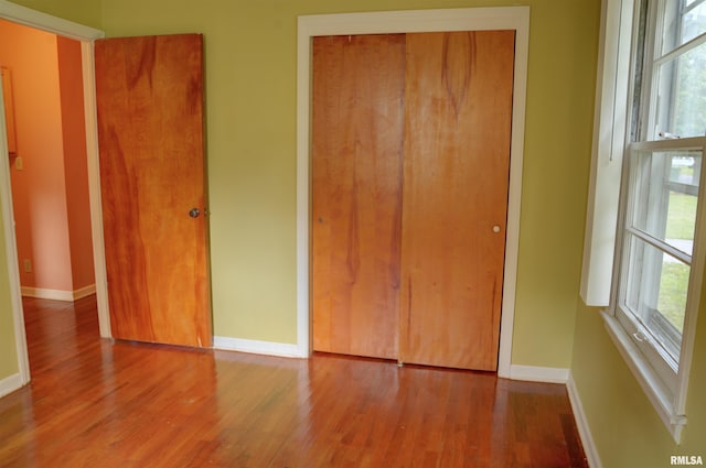 unfurnished bedroom with wood-type flooring and a closet