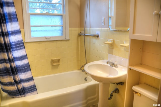 full bathroom featuring toilet, tile walls, shower / tub combo with curtain, backsplash, and sink