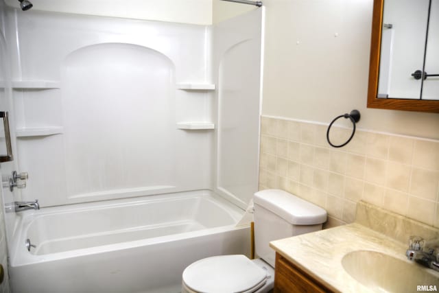 full bathroom with washtub / shower combination, vanity, toilet, and tile walls