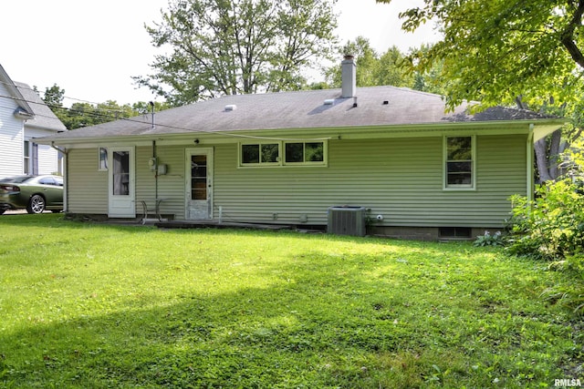 rear view of house with a yard and central air condition unit