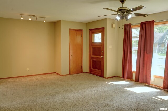 entryway with rail lighting, carpet, ceiling fan, and a wealth of natural light