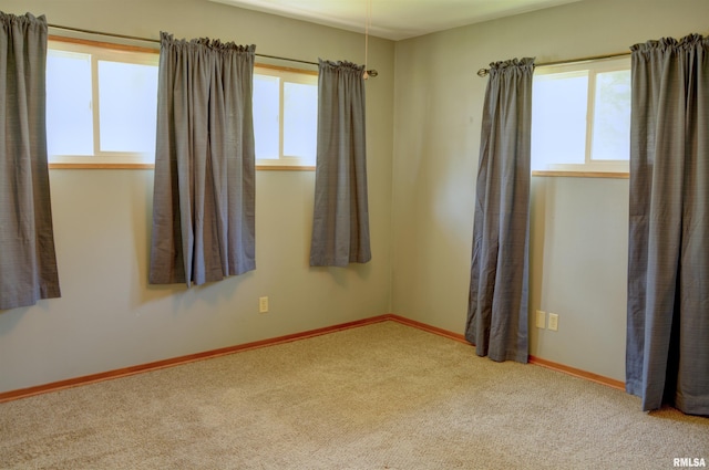 carpeted empty room featuring a wealth of natural light