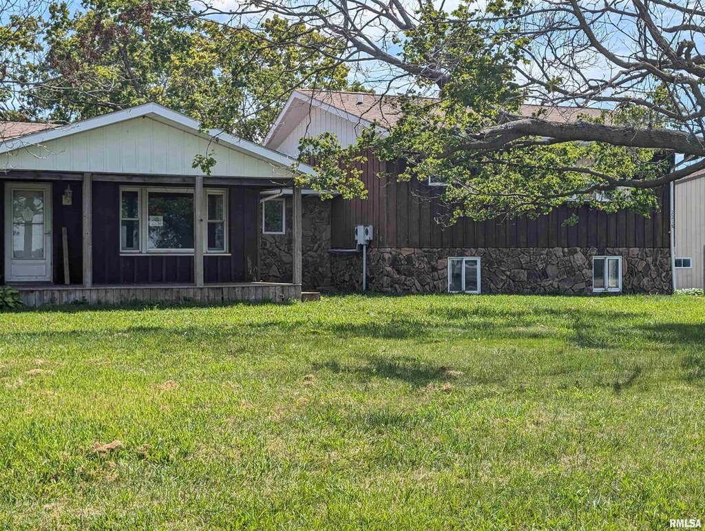 2218 S Trivoli Rd, Trivoli, IL 61569 - view of front of house featuring a porch, central air condition unit, a front yard, and stone siding