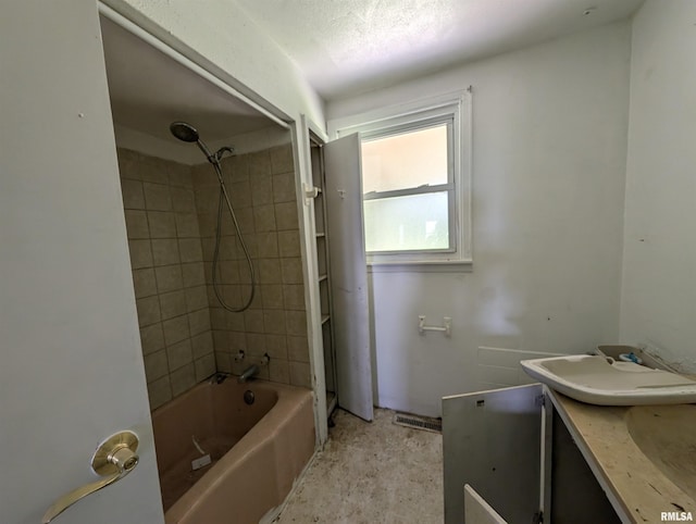 bathroom featuring vanity and tiled shower / bath combo