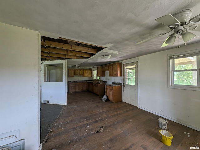 kitchen with dark wood-type flooring, a textured ceiling, and ceiling fan