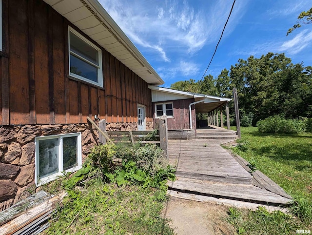 view of side of property with a wooden deck and a lawn