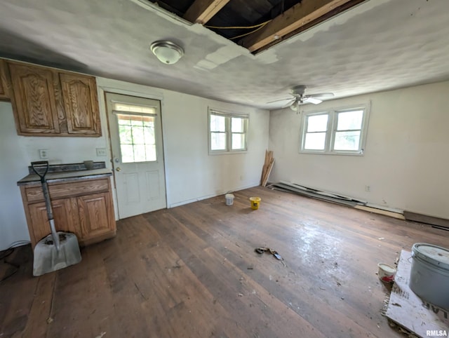 kitchen featuring ceiling fan, plenty of natural light, dark hardwood / wood-style flooring, and a baseboard heating unit