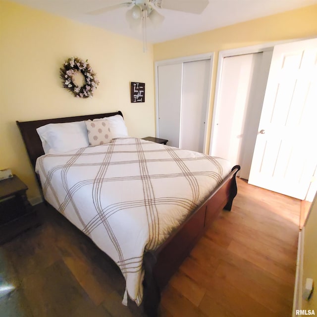 bedroom with multiple closets, ceiling fan, and hardwood / wood-style flooring