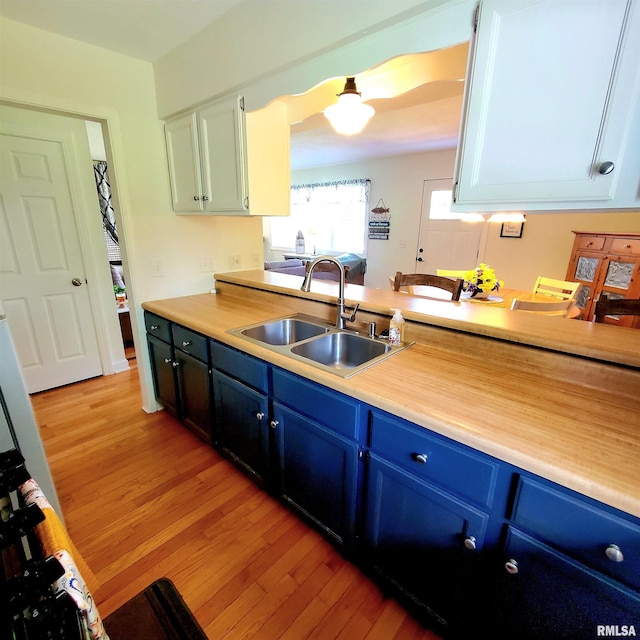 kitchen featuring sink, white cabinets, and light hardwood / wood-style floors