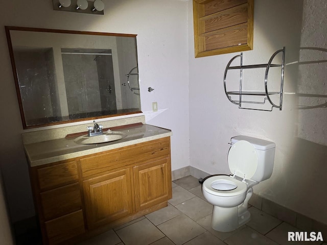 bathroom with a shower, vanity, toilet, and tile patterned floors