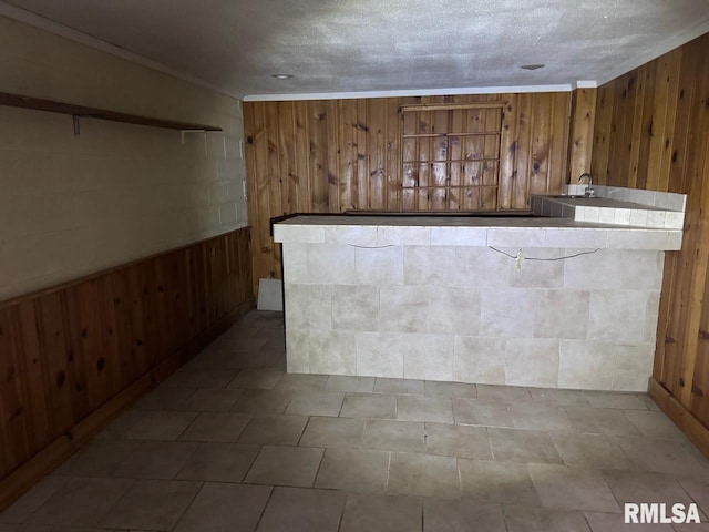 bar with wood walls and crown molding