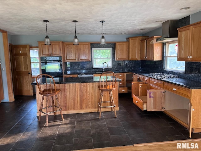 kitchen with pendant lighting, a breakfast bar area, a kitchen island, decorative backsplash, and appliances with stainless steel finishes